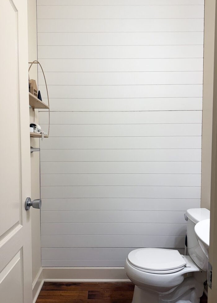 White shiplap wall paneling hung on a bathroom wall