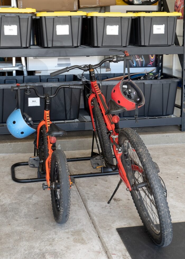 Two kid bikes stored in a floor bike rack