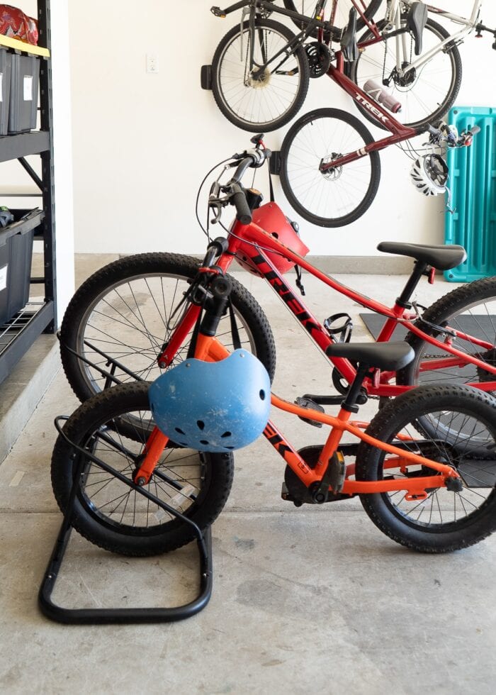 Two kid bikes stored in a floor bike rack