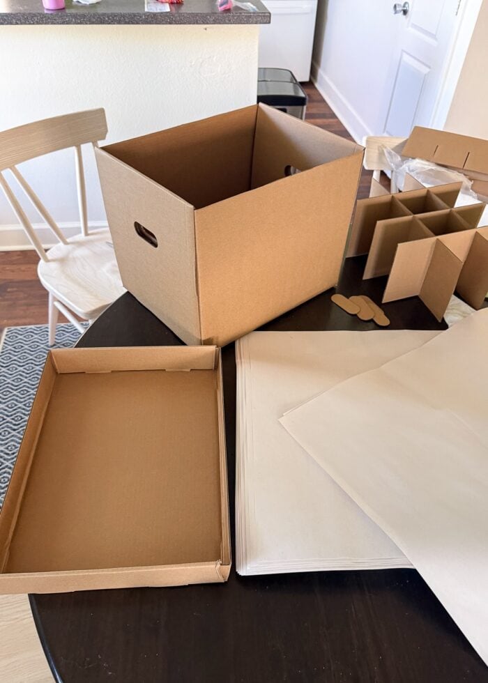 Moving box and and packing paper sitting on a kitchen table