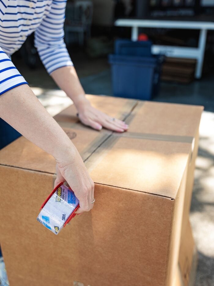Megan taping up a moving box with packing tape