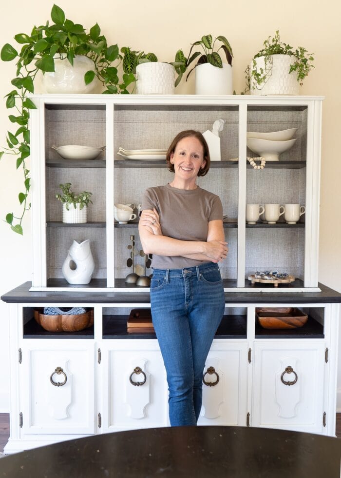 Megan in front of a white dining hutch