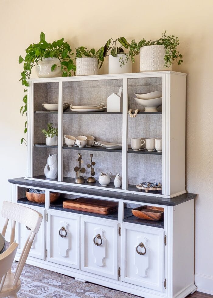 A white dining hutch covers up a window on a cream wall