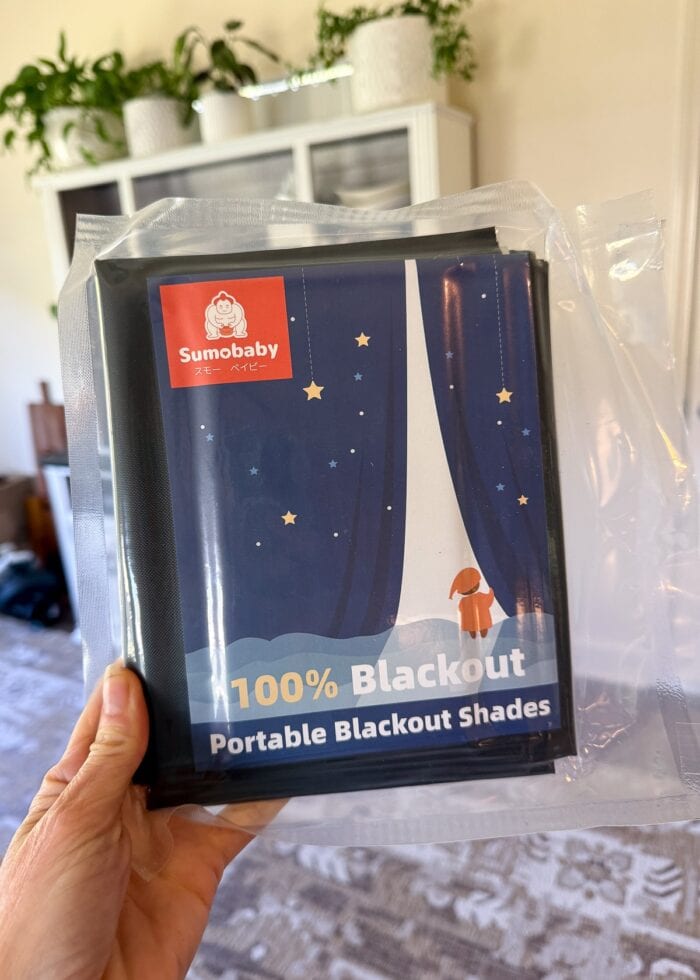 Hand holing a blackout shade in packaging