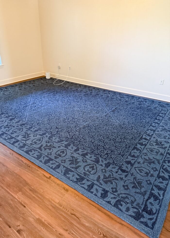 A new blue rug unrolled in am empty living room