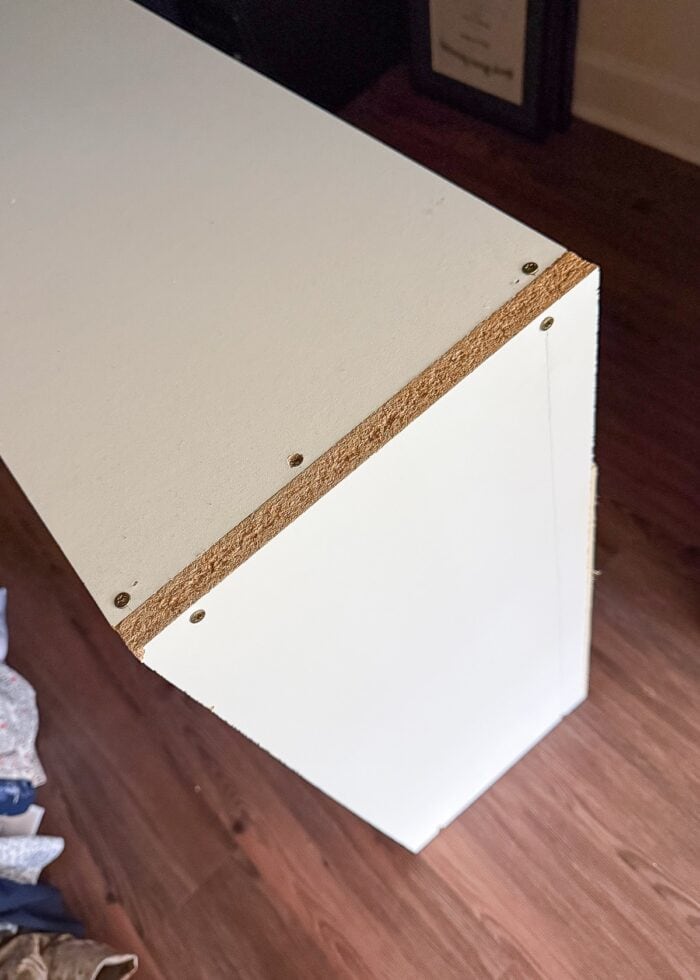 Corner of a DIY shoe storage shelf, showing how it is screwed together