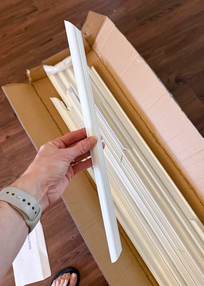 Megan holding a piece of pre-cut white PVC trim
