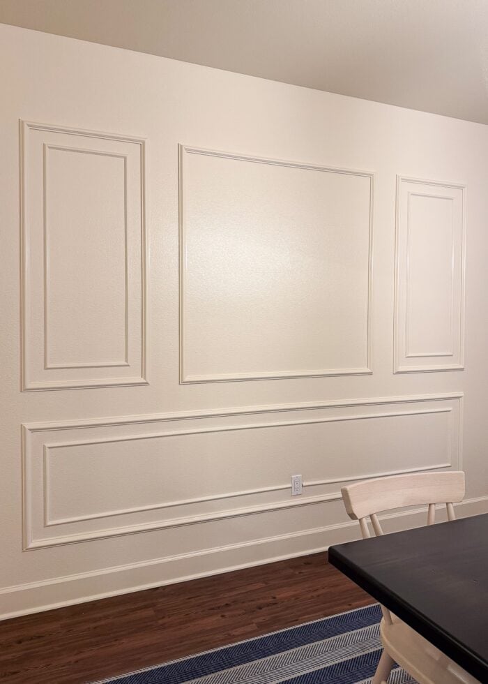 A cream wall with a trim design painted the same wall color