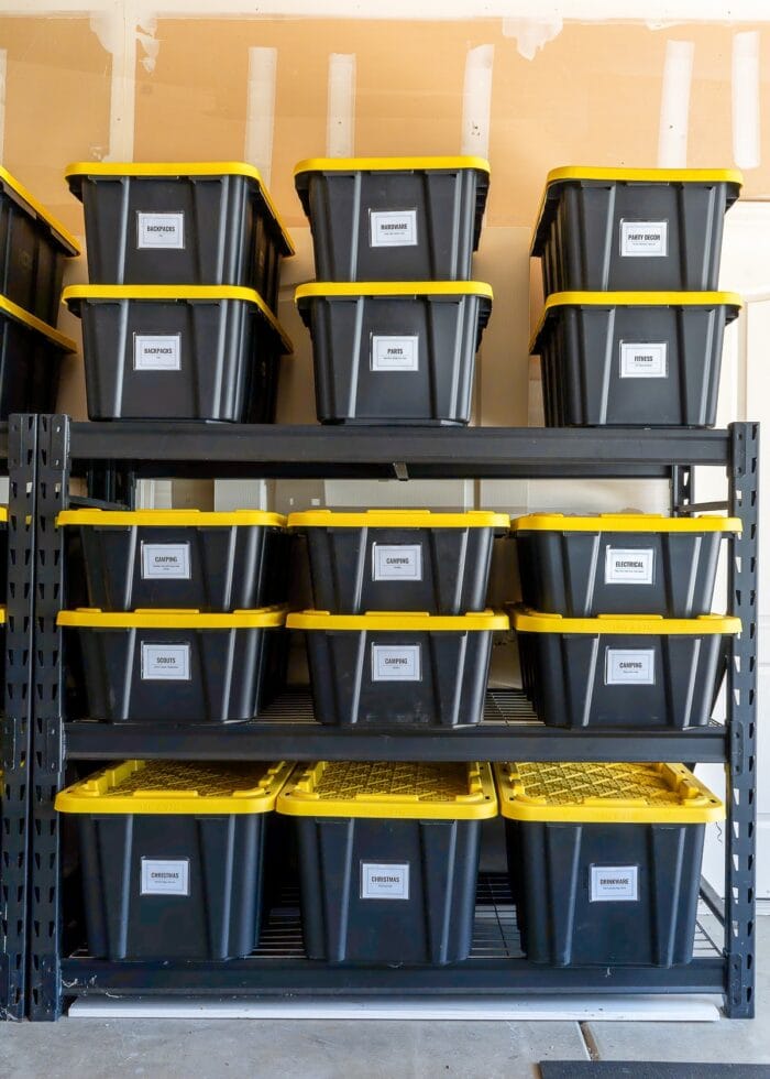 Black shelves in a garage filled with different sizes of black and yellow HDX bins.