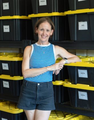 Megan from The Homes I Have Made standing in front of a shelf full of HDX bins.