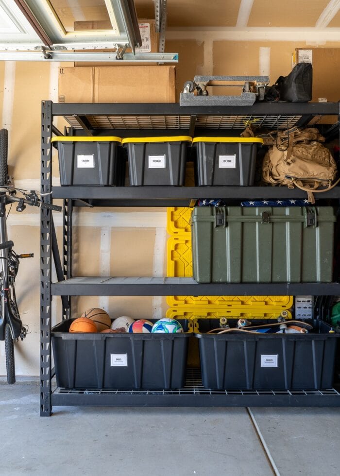 A tall Hefty garage shelf with large HDX bins on it.