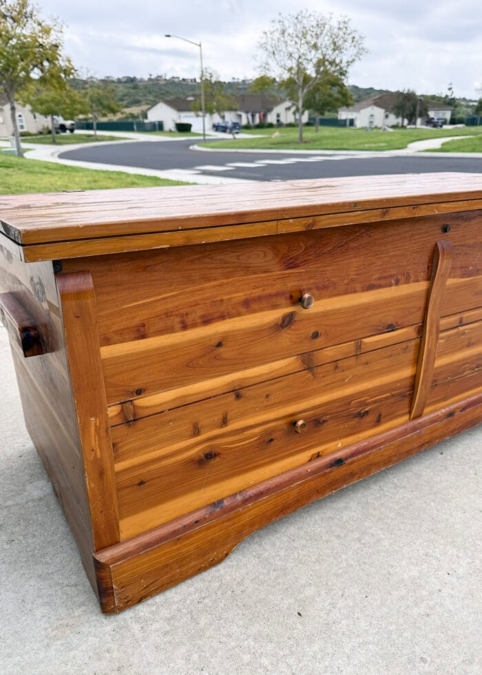 Vintage old cedar chest sitting on a driveway