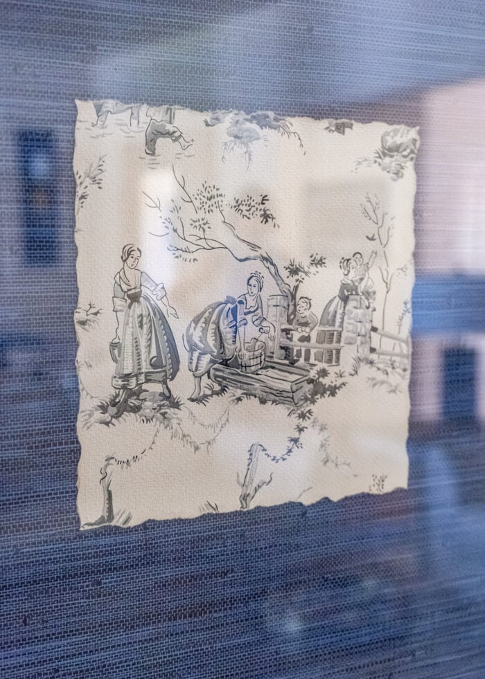 A black and white art print made from vintage wallpaper matted on blue grasscloth wallpaper