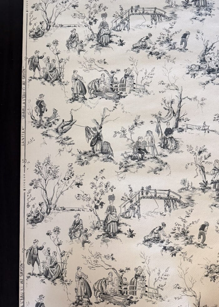 A roll of French vintage wallpaper with black and white illustrations on it