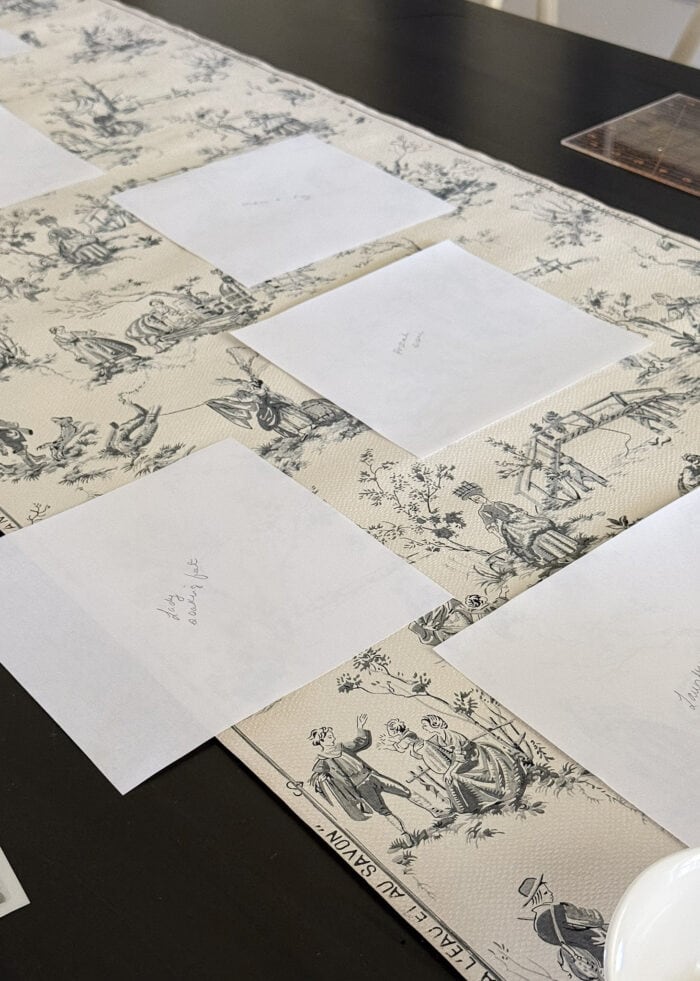 Paper square templates sitting on top of a roll of French vintage wallpaper