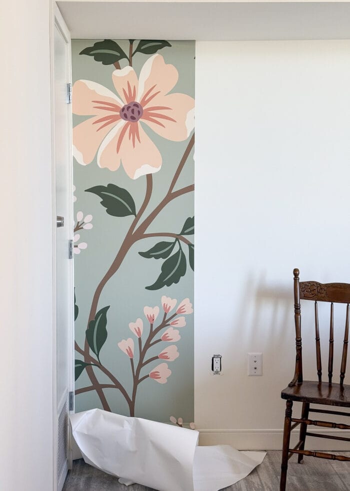 The first panel of a peel and stick wall mural hung on a white wall