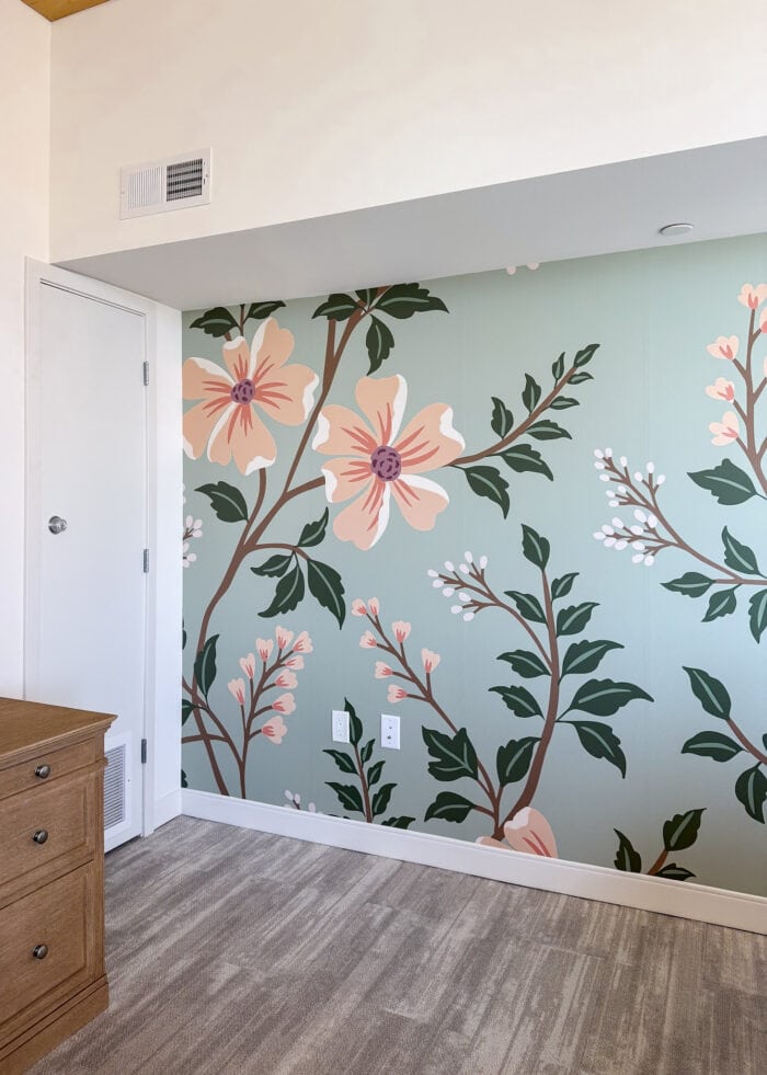 A beautiful peach and mint floral mural hung on an apartment wall.