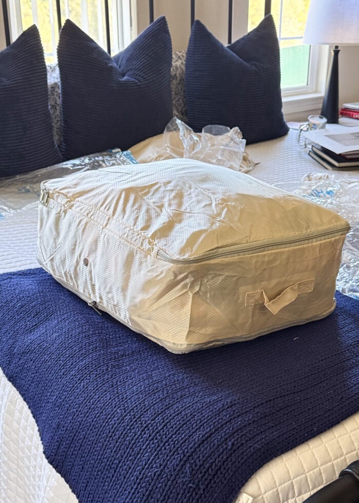 A compression bag all zipped up on a bed