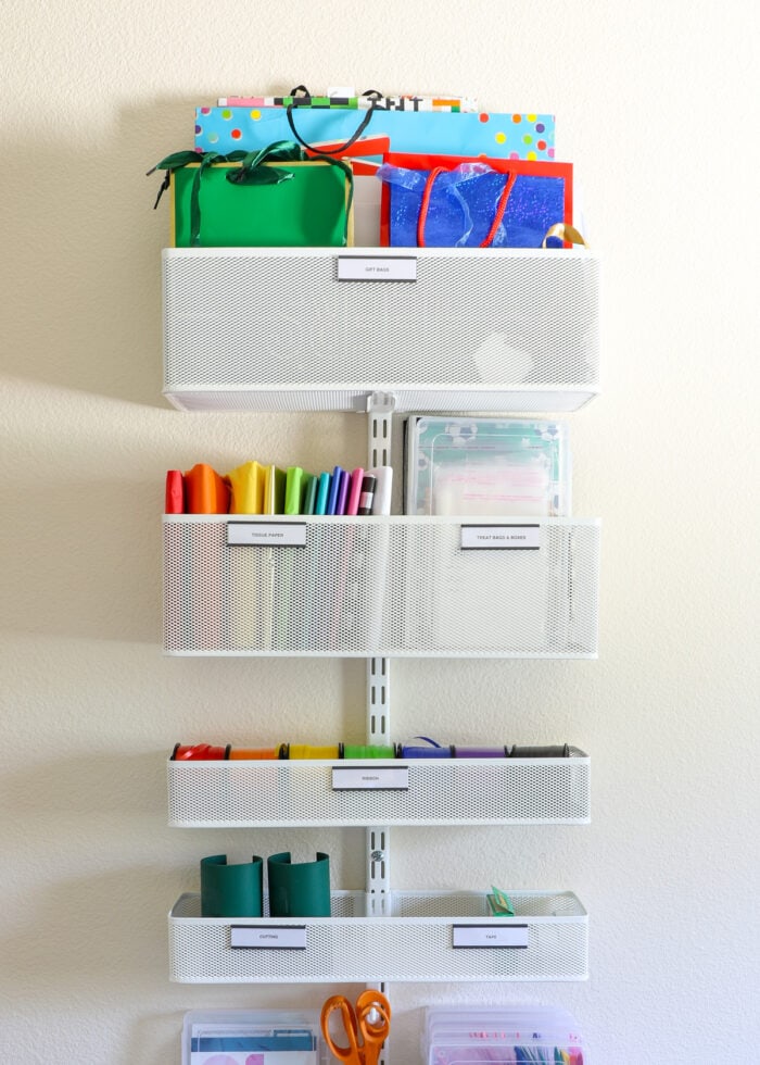 An Elfa storage rack mounted to a wall filled with gift wrapping supplies