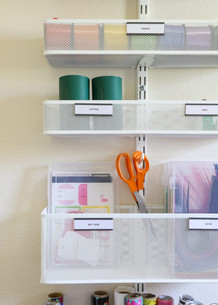 Scissors and gift tags and ribbon loaded into an Elfa system mounted on a wall