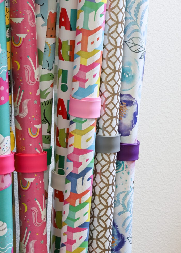 Colorful wrapping paper holders securing rolls of wrapping paper