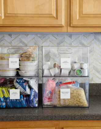 Four clear containers sitting on a kitchen counter holding pantry backstock