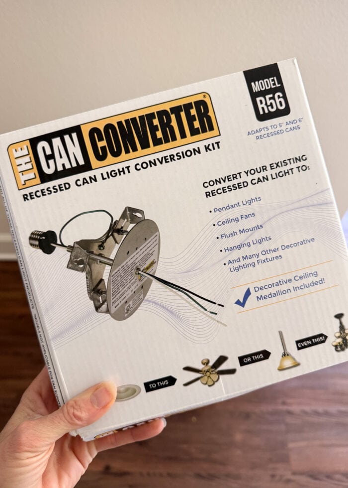 A hand holding a can light conversion kit