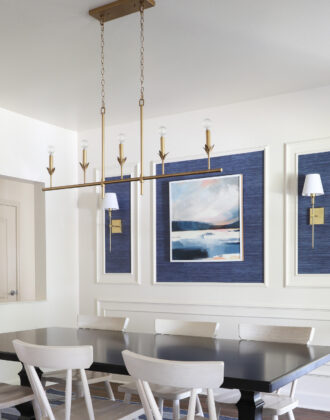 A long thin gold light fixture hung above a dining room table