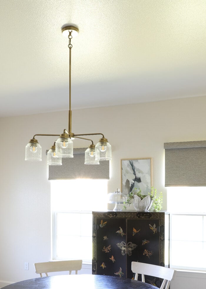 A gold 5-light fixture hung above a kitchen table